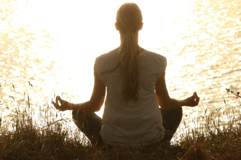 Woman practicing yoga at sunset